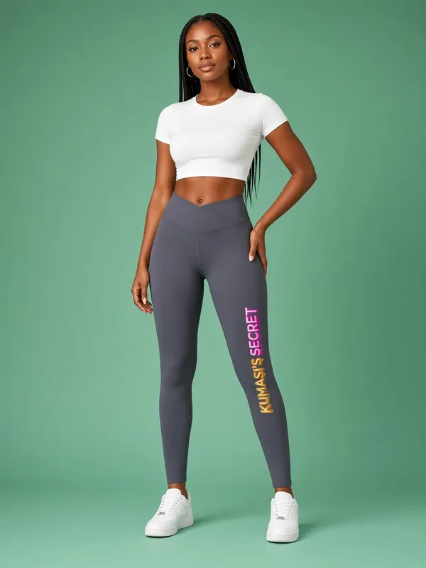 Model wearing the Kumasi's Secret leggings with pink and gold vertical lettering, view 1