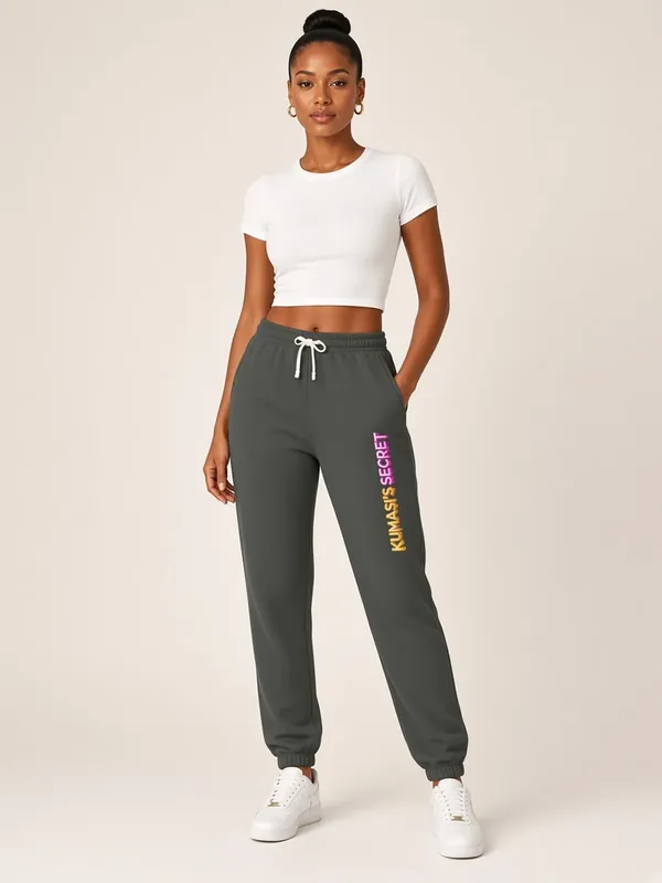 Model wearing the Kumasi's Secret charcoal jogger sweatpants with vertical lettering, view 1